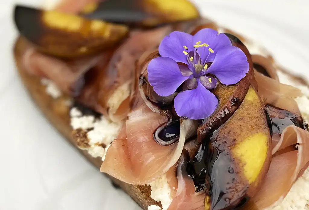 Toast de requesón con jamón serrano, duraznos de California